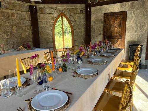 a long table with plates and glasses and flowers on it at Ironland Roztocze in Ruda Żelazna