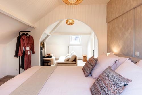 a bedroom with a large white bed with an archway at B&B Maison La Belle in Zoutleeuw