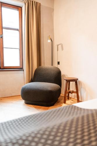 a chair sitting on the floor next to a bed at H5 Grauer Bär Studios & More in Innsbruck