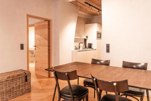 a dining room with a wooden table and chairs at H5 Grauer Bär Studios & More in Innsbruck