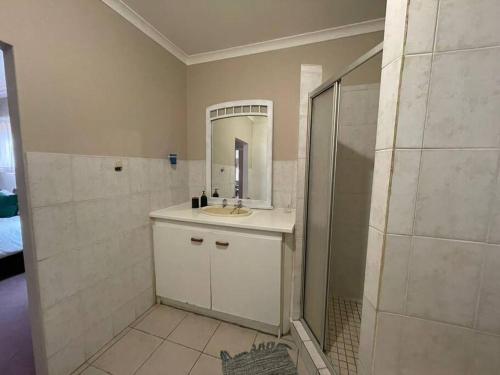 a bathroom with a sink and a shower with a mirror at Hillcrest/Waterfall Garden Hideaway! in Waterfall