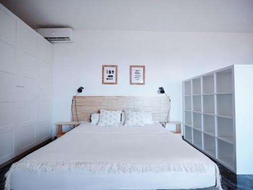 a bedroom with a large bed with white sheets at A+View Private Terrace Private Pool Family Fun in Badalona