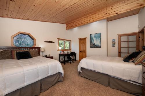 a bedroom with two beds and a desk in it at The Gemstone Grand by Leavetown Vacations in Grand Lake