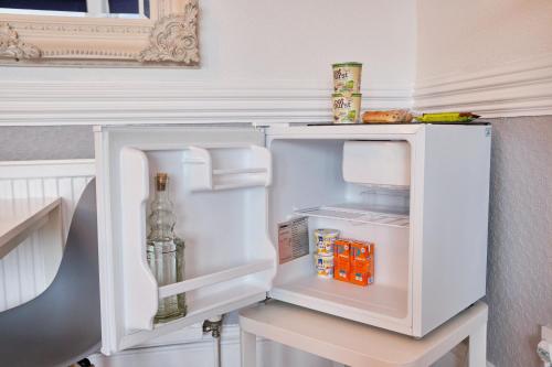 um frigorífico branco com a porta aberta numa cozinha em MacKays em Oban