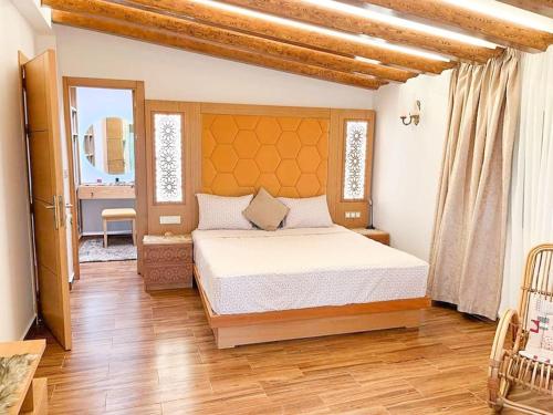a bedroom with a bed and a wooden floor at Tranquila Vista - Villa au cœur de la nature in Tangier