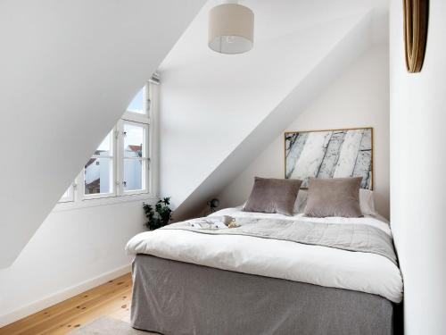 a bedroom with a bed with white walls at Sanders Saint - Loft One-Bedroom Apartment By the Charming Canals in Copenhagen