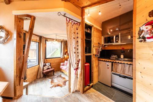 une cuisine avec une porte ouverte dans une petite maison dans l'établissement La Grange - IMMODREAMS - Avoriaz, à Avoriaz