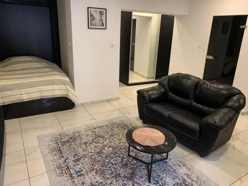 a living room with a leather couch and a table at Green View Kotlarska in Wrocław