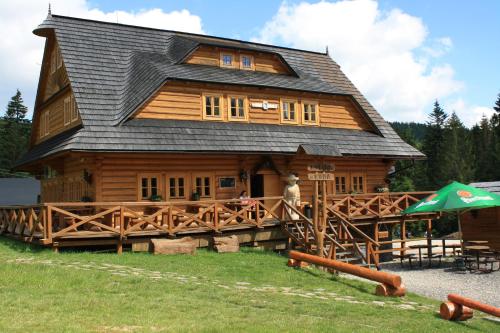 a large wooden cabin with a gambrel roof at Koliba u Kuba a rekreačné domy in Hruštín