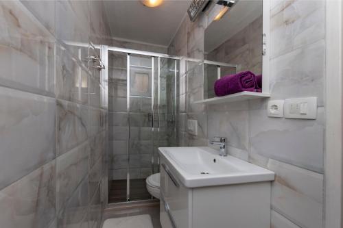 オミシュにあるApartment and Rooms Tatjanaのトイレと洗面台を備えた白いバスルーム