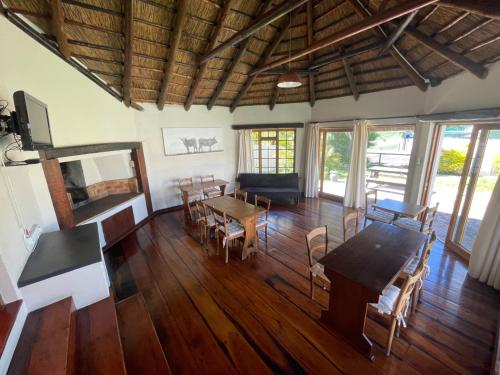 a living room with wooden floors and a table and chairs at Unique Guest House in Hallack Rock