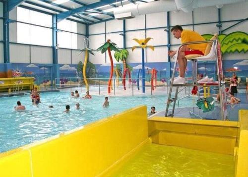 a man sitting on a chair in a swimming pool at Static caravan golden palm resort in Skegness