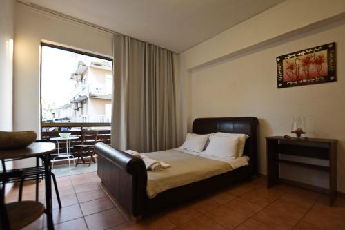 a hotel room with a bed and a balcony at Marnin Apartments in Rhodes Town