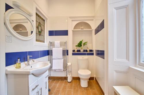 a bathroom with blue and white walls and a sink and a toilet at MacKays in Oban