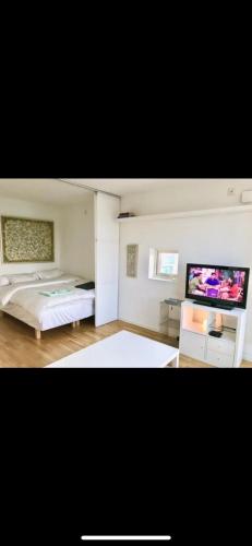 een slaapkamer met een bed en een flatscreen-tv bij Lottas Lovely Loft in Bunkeflostrand