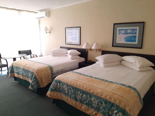 a hotel room with two beds and a table at Wilderness Beach Hotel in Wilderness