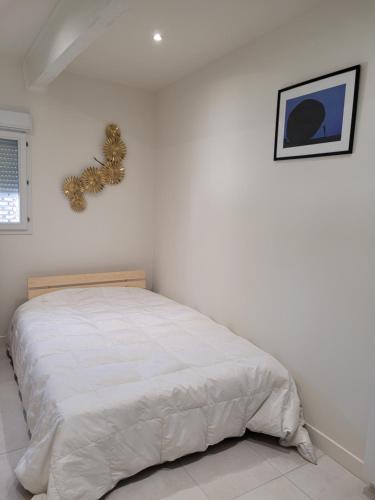 ein Schlafzimmer mit einem Bett mit einem Weihnachtskranz an der Wand in der Unterkunft Gîte de charme Le Fournil in Layrac