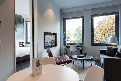 a room with a living room with a couch and a table at B-aparthotel Kennedy in The Hague