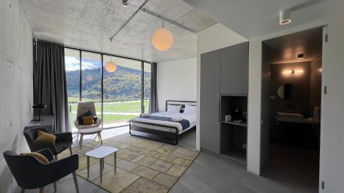 1 dormitorio con 1 cama, mesa y sillas en Concept Hotel by COAF, en Debed