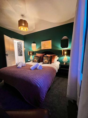 a bedroom with a large bed with purple sheets at Canalside Terrace-Boutique Stay Worcester City in Worcester