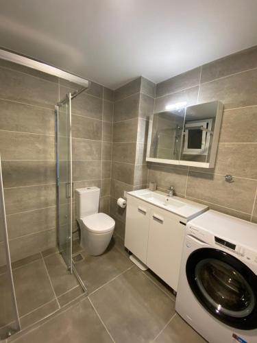 un bagno con WC e lavatrice di Athens Market Apartments, Amazing Acropolis View ad Atene
