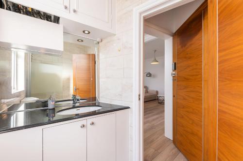 a kitchen with a sink and a mirror at The High Street Kensington Boutique in London