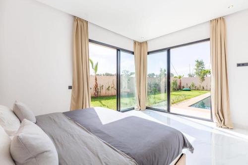 - une chambre avec un lit et une grande fenêtre dans l'établissement Luxury stylish 3suits villa, à Marrakech