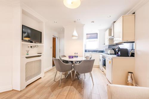 a kitchen with a table and chairs in a room at The High Street Kensington Boutique in London