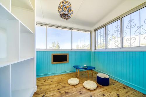 a room with blue walls and a table and two stools at Kaz Trou d Eau in Saint-Paul