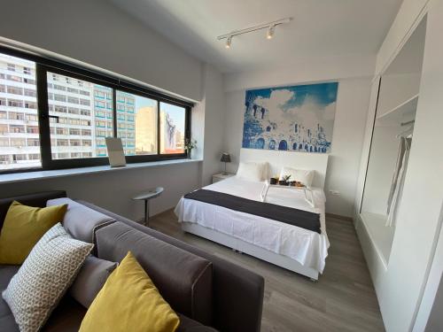 una camera da letto con un letto e un divano di Athens Market Apartments, Amazing Acropolis View ad Atene
