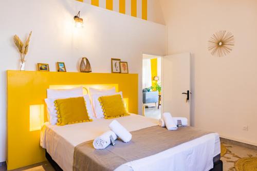 a bedroom with a large bed with a yellow headboard at Kaz Zevi in Saint-Paul