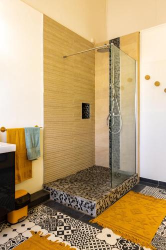 a shower with a glass door in a bathroom at Kaz Zevi in Saint-Paul