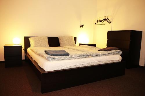 1 dormitorio con 1 cama con 2 mesitas de noche y 2 luces en Cozy Apartment in the Middle of Bratislava, en Bratislava