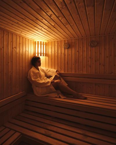 a woman is sitting in a sauna at Triumph White Sands Hotel in Marsa Matruh