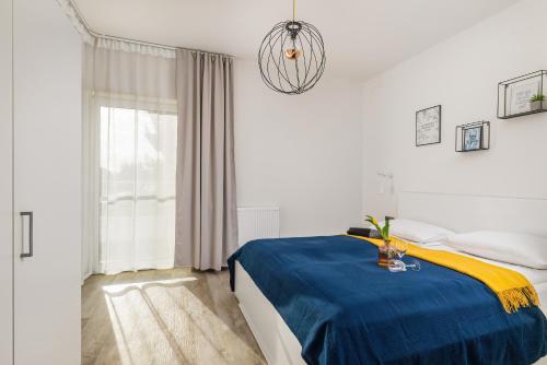 a bedroom with a bed with a blue and yellow blanket at Apartment Five Seas with Parking & Swimming Pool by Renters in Sianozety