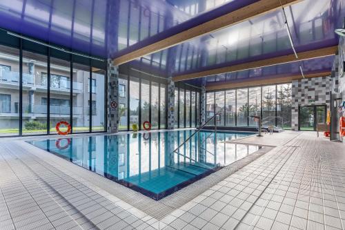 a large swimming pool in a building with windows at Apartment Five Seas with Parking & Swimming Pool by Renters in Sianozety