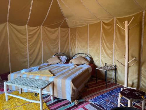 ein Schlafzimmer mit einem Bett in einem Zelt in der Unterkunft Authentique berber Camp in M’hamid El Ghizlane