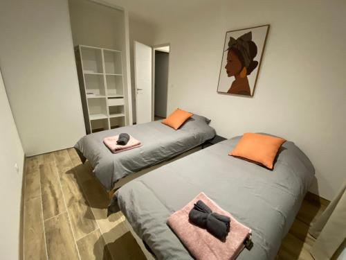 two beds in a small room with pink towels at Villas Cabiscol in Beaucaire