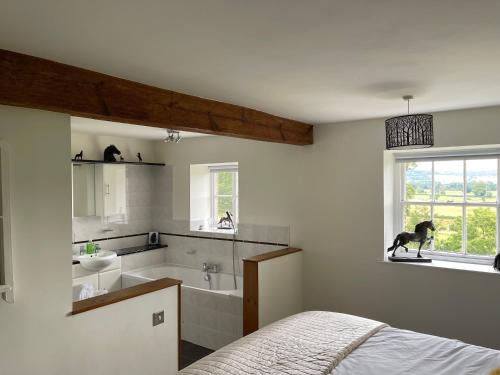 a bedroom with a dog standing in the window at Greenbank Farm House in Cartmel
