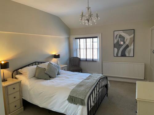 a bedroom with a large bed and a chandelier at Townhouse Apartment in Oswestry