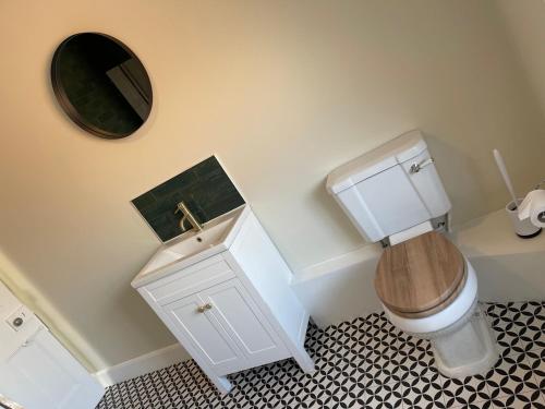 a bathroom with a toilet and a sink and a mirror at Townhouse Apartment in Oswestry
