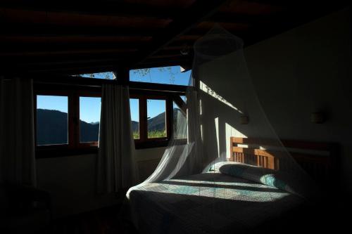 a bedroom with a bed with a window with a view at Eco Lodge de Construção Natural com Vista Panorâmica in Nova Friburgo