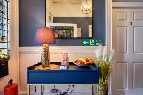 a table with a lamp and a bowl of fruit on it at MacKays in Oban