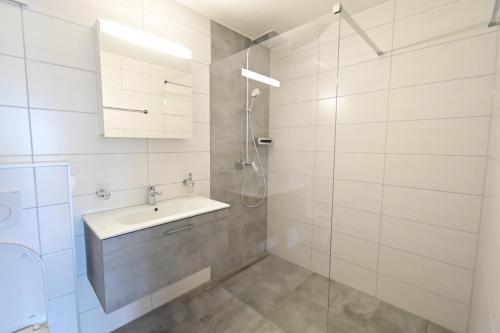 a bathroom with a sink and a shower at Mountain view apartment in Cressier near Murten 