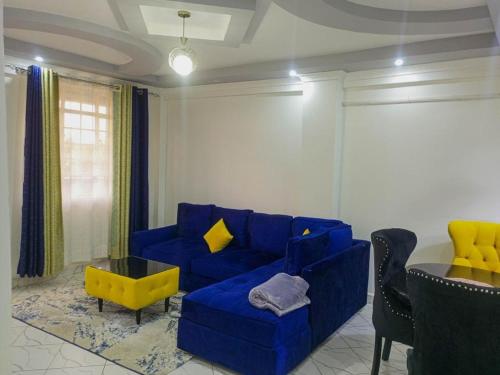 a living room with a blue couch and a table at Chloe One Bedroom in Nanyuki