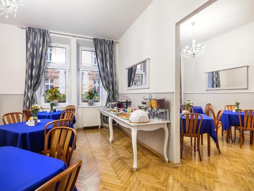 un comedor con mesas y sillas azules en Kosmopolita Rooms, en Cracovia