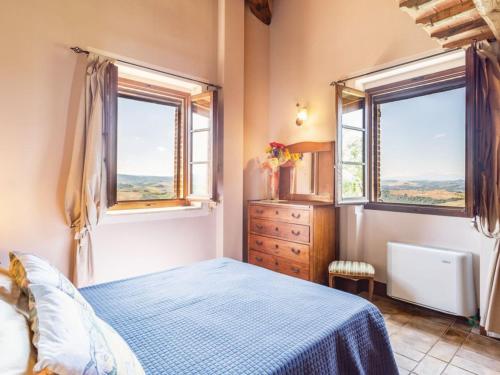 a bedroom with a bed and two windows at La Casa Di Bice in Asciano