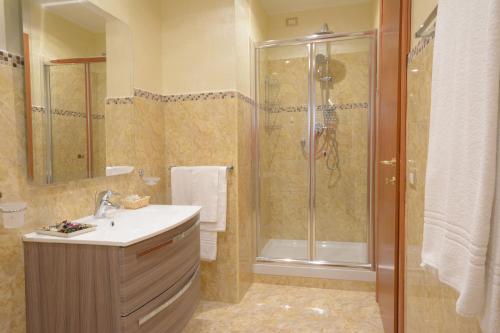 y baño con ducha y lavamanos. en Hotel President, en Chianciano Terme