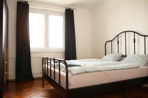 1 dormitorio con cama negra y ventana en New colorful apartment with big balcony, en Koliba