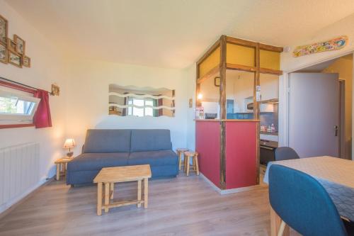 a living room with a blue couch and a kitchen at Le Sunny Snow - Jolie vue montagne in Les Orres